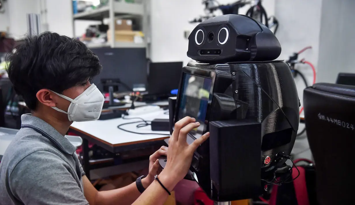 Mahasiswa menonfigurasi robot medis yang dimodifikasi untuk memeriksa pasien virus corona COVID-19 di Regional Center of Robotics Technology, Chulalongkorn University, Bangkok, Thailand, Rabu (18/3/2020). Thailand mengerahkan robot ‘Ninja’ untuk membantu memerangi COVID-19. (LILLIAN SUWANRUMPHA/AFP)