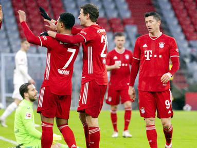 Para pemain Bayern Munchen merayakan gol yang dicetak oleh Serge Gnabry ke gawang Hoffenheim pada laga Bundesliga di Stadion Allianz Arena, Sabtu (30/1/2021). Bayern Munchen menang dengan skor 4-1. (Sven Hoppe/dpa via AP)