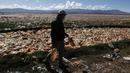 Limbert Sanchez, anggota Pusat Ekologi dan Masyarakat Andes, membawa botol yang diambil dari lautan sampah yang memenuhi Sungai Tagaret, Bolivia, yang kering, Kamis (25/3/2021). Sungai ini mengalir ke Danau Uru Uru dengan membawa sampah-sampah yang mencemari danau. (AP Photo / Juan Karita)