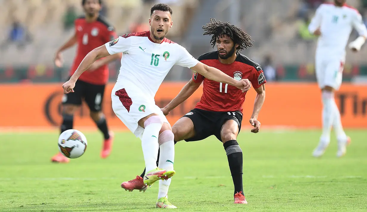 Gelandang Maroko Selim Amallah (kiri) berebut bola dengan gelandang Mesir Mohamed Elneny selama pertandingan perempat final Piala Afrika (CAN) 2021 di Stade Ahmadou Ahidjo di Yaounde (30/1/2022). Mesir menang atas Maroko 2-1. (AFP/Charly Triballeau)
