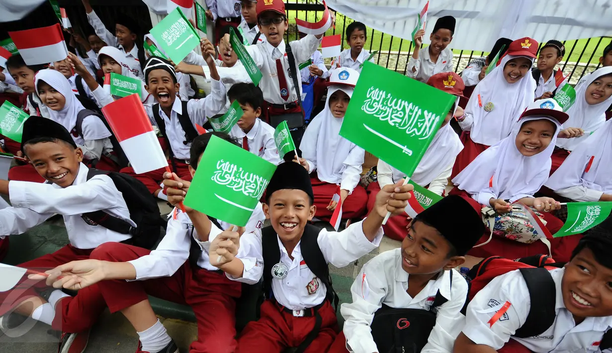 Pelajar SD mengibarkan bendera kedua negara untuk menyambut kedatangan Presiden Joko Widodo bersama Raja Arab Saudi, Salman bin Abdulaziz di sekitar Istana Bogor, Rabu (1/3). Puluhan ribu pelajar akan menyambut. (Liputan6.com/Helmi Fithriansyah)