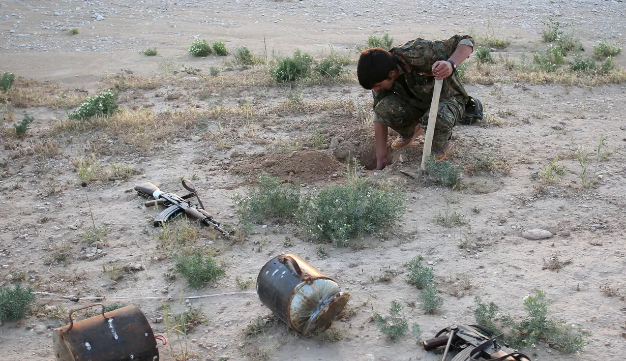 Anggota dari Unit Perlawanan Sinjar (YBS) yang berafiliasi dengan Partai Pekerja Kurdistan (PKK) memasang ranjau darat di sebuah jalur yang dilintasi kelommpok ekstremis ISIS dekat Desa Umm al-Dhiban, Irak utara, 30 April 2016. (REUTERS/Goran Tomasevic)
