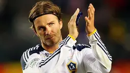 Gelandang LA Galaxy David Beckham memberi sambutan ke arah fans pada lanjutan Major League Soccer melawan DC United di Carson, California. Victor Decolongon/Getty Images/AFP