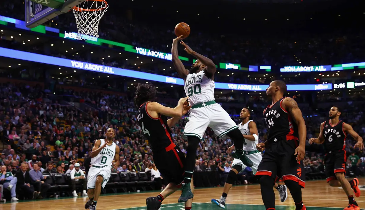 Pemain Cetics, Amir Johnson #90 melakukan tembakan saat dihadang pemain Toronto Raptors, Luis Scola #4 pada lanjutan NBA di TD Garden, Boston, Massachusetts, Kamis (24/3/2016) WIB. Celtics menang 91-79. (Maddie Meyer/Getty Images/AFP)