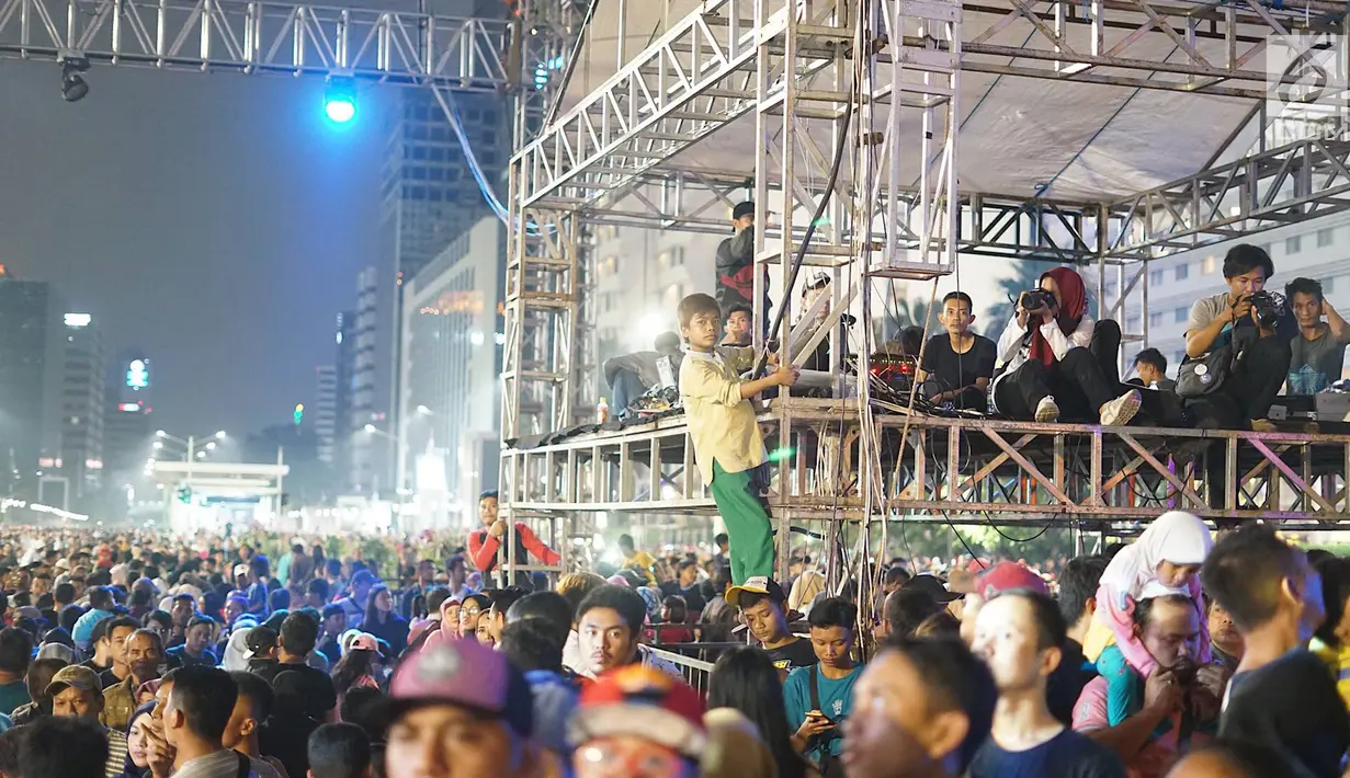 Sejumah remaja menyaksikan hiburan dari panggung kontrol pada malam puncak peringatan HUT DKI Jakarta ke-492 di Bundaran HI Jakarta, Sabtu, (22/6/2019). HUT DKI Jakarta yang dikemas dalam konsep ekonomi kreatif dan seni dibuka Gubernur DKI Jakarta Anies Baswedan. (Liputan6.com/Immanuel Antonius)