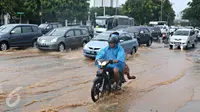Pengendara sepeda motor melintasi genangan air yang merendam jalan di depan Istana Merdeka, Jakarta, Selasa (9/2). Hujan deras yang mengguyur kota Jakarta membuat sejumlah jalan protokol tergenang air. (Liputan6.com/Immanuel Antonius)