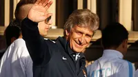 Pelatih Manchester City, Manuel Pellegrini, melambaikan tangan ke arah ribuan suporter yang memadati jalan-jalan untuk menyaksikan parade dua gelar juara "The Citizens" musim 2013/2014, (13/5/2014). (REUTERS/Phil Noble)