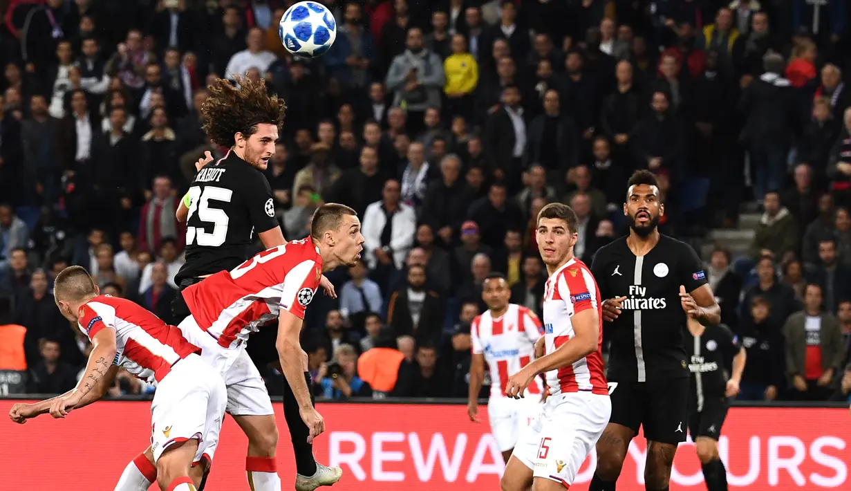 Gelandang PSG, Adrien Rabiot, duel udara dengan bek Red Star, Milan Rodic, pada laga Liga Champions di Stadion Parc des Princes, Paris, Rabu (3/10/2018). PSG menang 6-1 atas Red Star. (AFP/Anne-Christine Poujoulat)