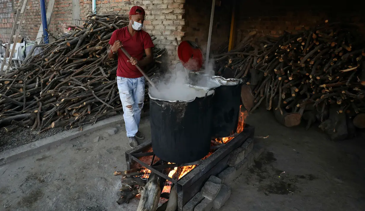 Relawan memasak kacang-kacangan untuk pengungsi Venezuela di tempat penampungan Divina Providencia, La Parada, Cucuta, Kolombia, Senin (18/2). Tempat penampungan ini melayani sekitar 4.500 makan siang per hari. (AP Photo/Fernando Vergara)