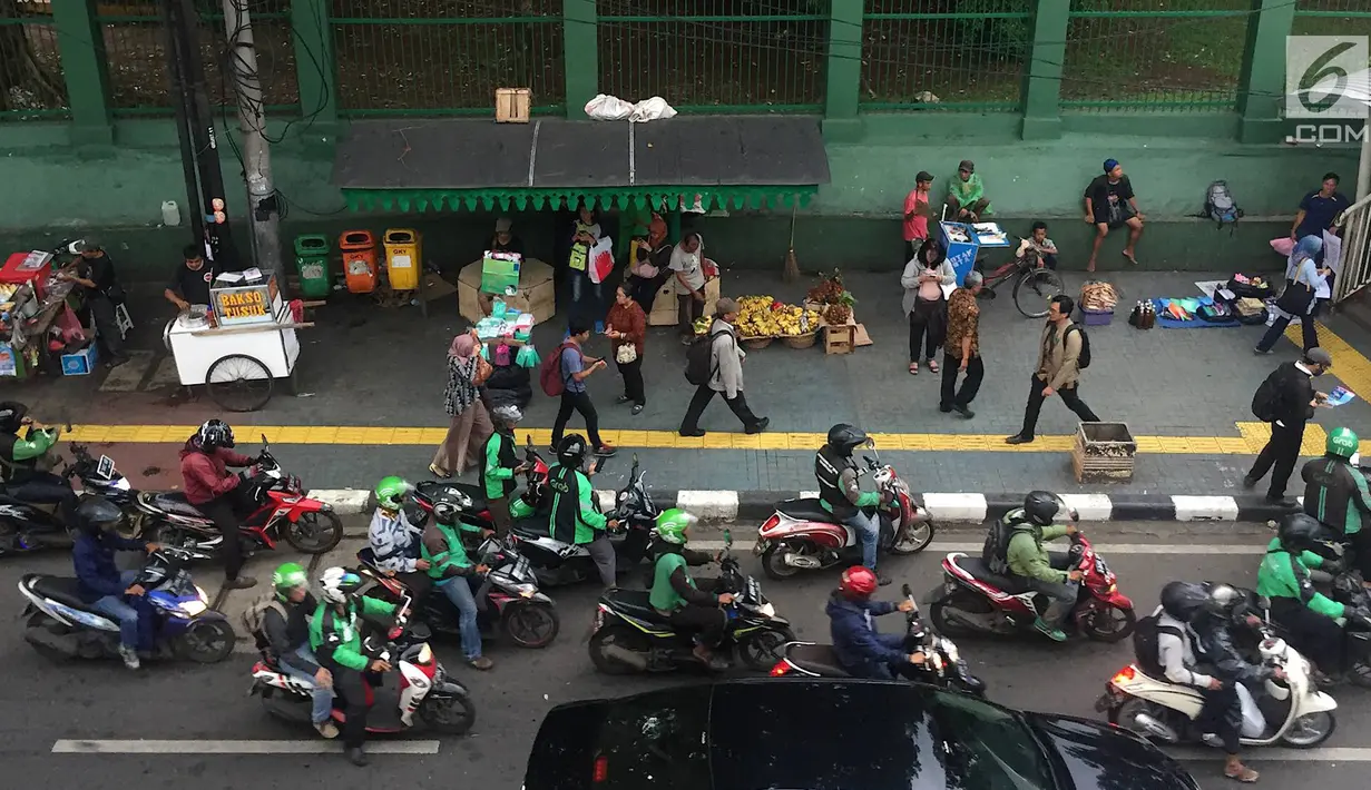 Pedagang kaki lima (PKL) dan ojek online memadati kawasan Stasiun Palmerah, Jakarta, Kamis (6/12). Kurangnya pengawasan petugas menyebabkan trotoar dan bahu jalan dipenuhi oleh PKL dan ojek online. (Liputan6.com/Immanuel Antonius)