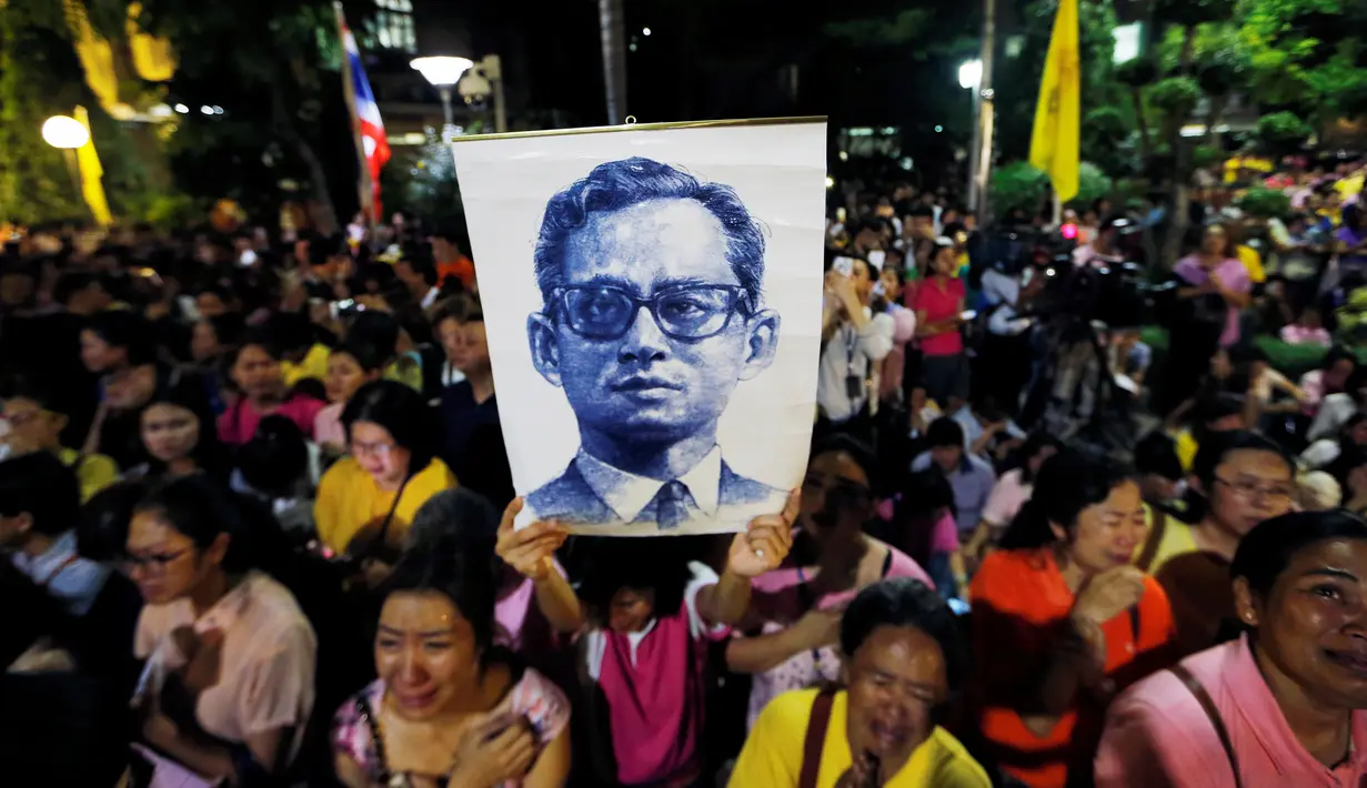 Rakyat Thailand membawa gambar Raja Thailand Bhumibol Adulyadej di luar RS Siriraj, Bangkok, Thailand, Kamis (13/10). (REUTERS / Jorge Silva)