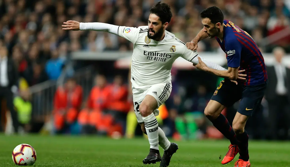 Gelandang Real Madrid, Isco membawa bola dari kawalan gelandang Barcelona, Sergio Busquets selama pertandingan lanjutan La Liga Spanyol di Santiago Bernabeu, Madrid (2/3). Barcelona menang tipis atas Real Madrid 1-0. (AP Photo/Manu Fernandez)