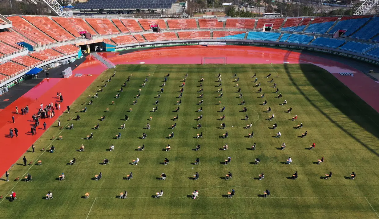 Pelamar kerja saat mengikuti ujian tertulis selama tes rekrutmen untuk Ansan Urban Corporation di stadion Wa di Ansan, Korea Selatan (4/8/2020).  Meski kasus corona di Korsel 10.384, dengan angka kematian 200 dan 6.776 sembuh, warga tetap mengikuti tes tersebut.  AFP/YONHAP)