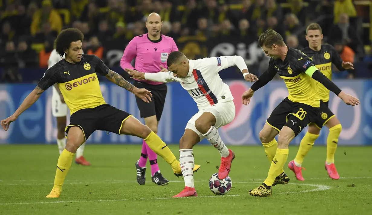 Striker Paris Saint-Germain, Kylian Mbappe, berebut bola dengan pemain Borussia Dortmund pada leg pertama 16 besar Liga Champions di Signal Iduna Park, Dortmund, Rabu (19/2) dini hari WIB. Dortmund menang 2-1 atas PSG. (AFP/Ina Fassbender)