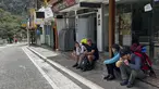Turis menunggu di luar stasiun kereta Machu Picchu setelah layanan kereta api dihentikan karena kerusakan yang diduga disebabkan oleh pengunjuk rasa di Machu Picchu, Peru, Sabtu (21/1/2023). Demonstrasi besar di Peru yang menentang pemerintahan masih belum usai dan menyebabkan tempat wisata terkenal Machu Picchu ditutup. (Photo by Carolina Paucar / AFP)