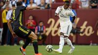 Striker Real Madrid Vinicius Junior mengumpan bola dari kawalan bek Juventus Giorgio Chiellini selama babak kedua pertandingan International Champions Cup (ICC) di Landover, Md (4/8). Madrid menang telak 3-1 atas Juventus. (AP Photo/Nick Wass)