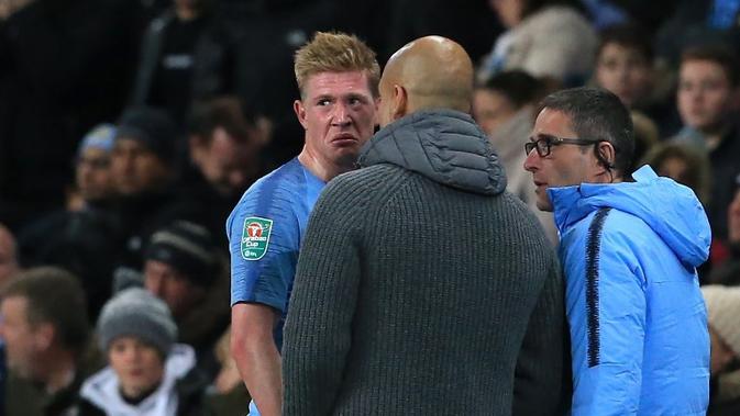 Gelandang Manchester City, Kevin de Bruyne (kiri), berbicara dengan Pep Guardiola (tengah) saat mengalami cedera pada laga melawan Fulham, di Etihad, Kamis (1/11/2018). (AFP/Lindsey Parnaby)