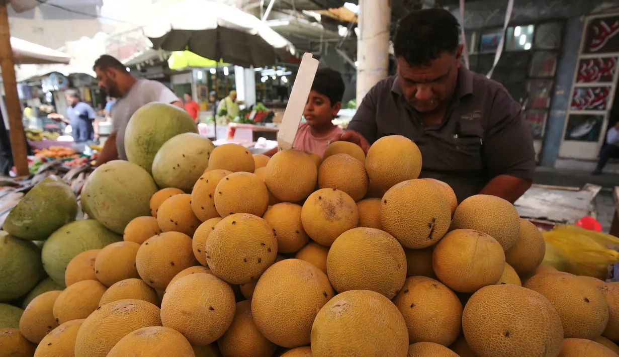Seorang pedagang menjual melon di pasar populer di Baghdad (24/5/2019). Baghdad adalah salah satu kota terbesar di dunia dan menjadi rumah bagi umat Muslim, Kristiani, Yahudi dan penganut paganisme dari seluruh Timur Tengah dan Asia Tengah. (AFP Photo/Ahmad Al-Rubaye)
