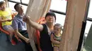 Seorang Ibu saat ingin menutup tirai untuk menyusui anaknya di dalam sebuah bus, kota Pingxiang, Provinsi Jiangxi, Cina. Beberapa kota didaerah Cina sudah menerapkan kursi khusus untuk ibu menyusui didalam angkutan umum. (shanghaiist.com)