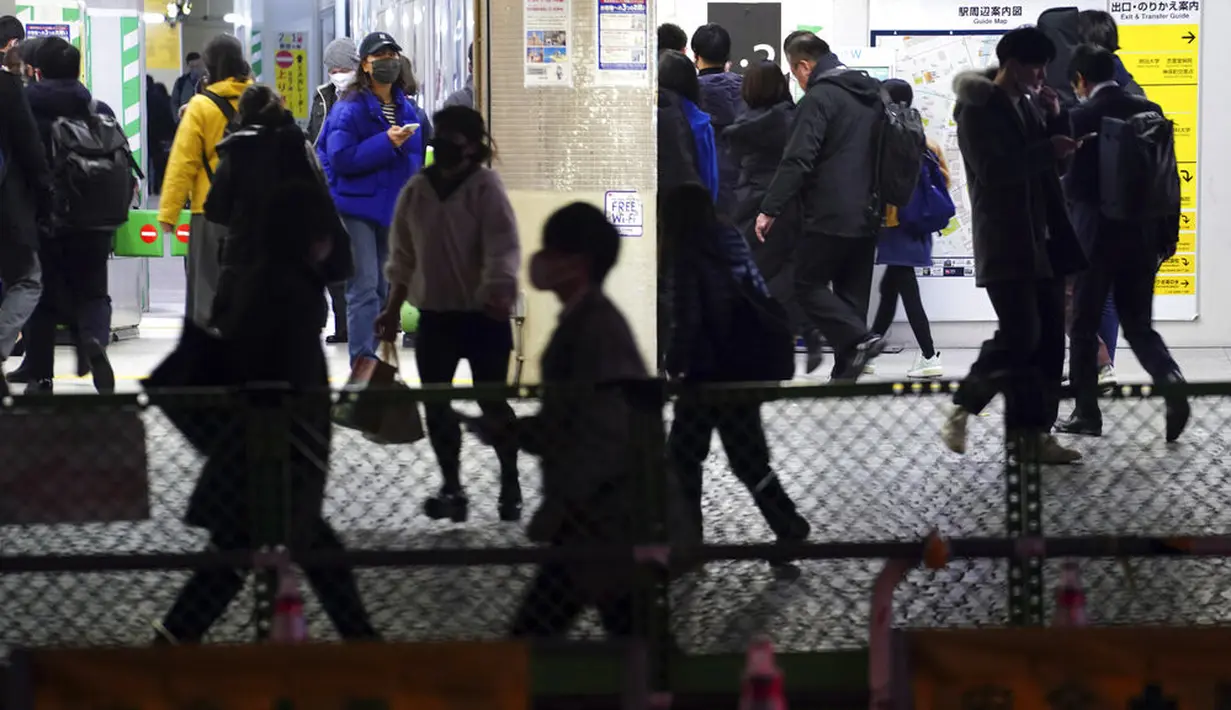 Orang-orang yang mengenakan masker untuk mengekang penyebaran virus corona COVID-19 berjalan melewati stasiun kereta api di Tokyo, Jepang, Rabu (6/1/2021). Ibu kota Jepang itu mengkonfirmasi lebih dari 1.500 kasus baru virus corona COVID-19 pada 6 Januari 2021. (AP Photo/Eugene Hoshiko)