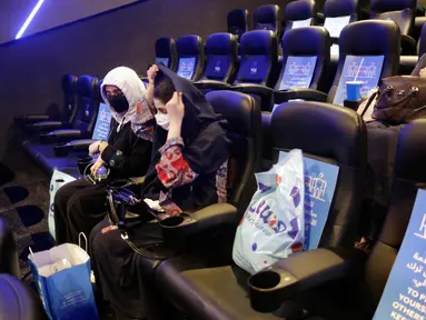 Perempuan Saudi mengenakan masker untuk mencegah penyebaran Covid-19 bersiap menyaksikan film di aula Bioskop VOX di Jiddah, Arab Saudi (26/6/2020). Pemerintah Arab Saudi membuka kembali bioskop setelah melonggarkan lockdown Covid-19. (AP Photo/Amr Nabil)