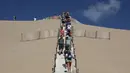 Orang-orang menaiki tangga di Dune du Pilat, bukit pasir tertinggi di Eropa, pada hari pembukaannya kembali setelah kebakaran hebat menghancurkan 7000 hektar hutan La Teste-de-Buch di dekatnya, di Pyla sur Mer , di Gironde, barat daya Prancis (27/7/2022). (AFP/Romain Perrocheau)