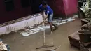 Warga membersihkan lumpur sisa banjir yang melanda kawasan Rawajati, Jakarta, Sabtu (27/4). Banjir akibat luapan air sungai Ciliwung sempat melanda kawasan ini pada Jumat (26/4). (Liputan6.com/Helmi Fithriansyah)