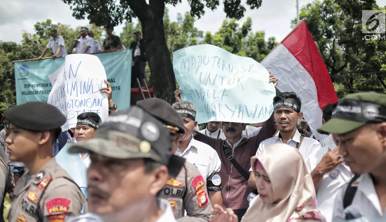 Massa dari Serikat Pegawai PD Pasar Jaya membawa poster dalam unjuk rasa di depan Balai Kota DKI Jakarta, Rabu (31/1). Dalam aksinya, mereka menolak tenaga profesional PKWT & PKWTT yang Kolusi, korupsi, Nepotisme (KKN).  (Liputan6.com/Faizal Fanani)