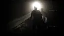 Penambang batu bara Bosnia berjalan di terowongan bawah tanah di sebuah tambang di Zenica, Bosnia (29/4/2021). Selama Ramadan, Muslim yang taat tidak makan, minum, dan merokok dari fajar hingga matahari terbenam dan penambang batu bara Zenica tidak terkecuali. (AP Photo/Kemal Softic)
