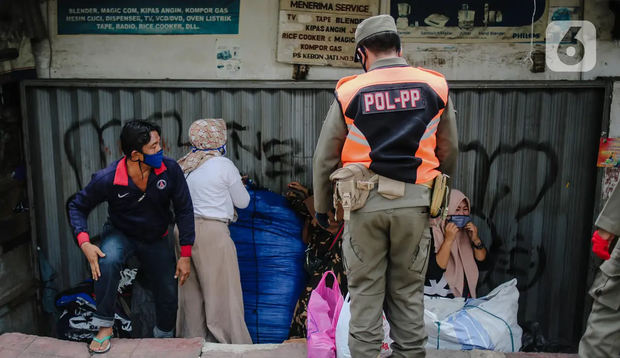 Petugas Satpol PP menertibkan pedagang yang nekat berjualan saat masa pandemi COVID-19 di kawasan Pasar Tanah Abang, Jakarta, Jumat (22/5/2020). Gubernur DKI Jakarta Anies Baswedan menambah PSBB selama 14 hari mulai tanggal 22 Mei 2020. (Liputan6.com/Faizal Fanani)