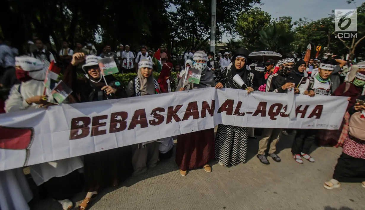 Massa membentangkan spanduk saat menggelar aksi terkait keuputusan Presiden AS, Donald Trump yang mengkali Yerusalem sebagi ibu kota Israel di depan kantor Kedutaan Besar AS, Jakarta, Jumat (8/11). (Liputan6.com/Faizal Fanani)