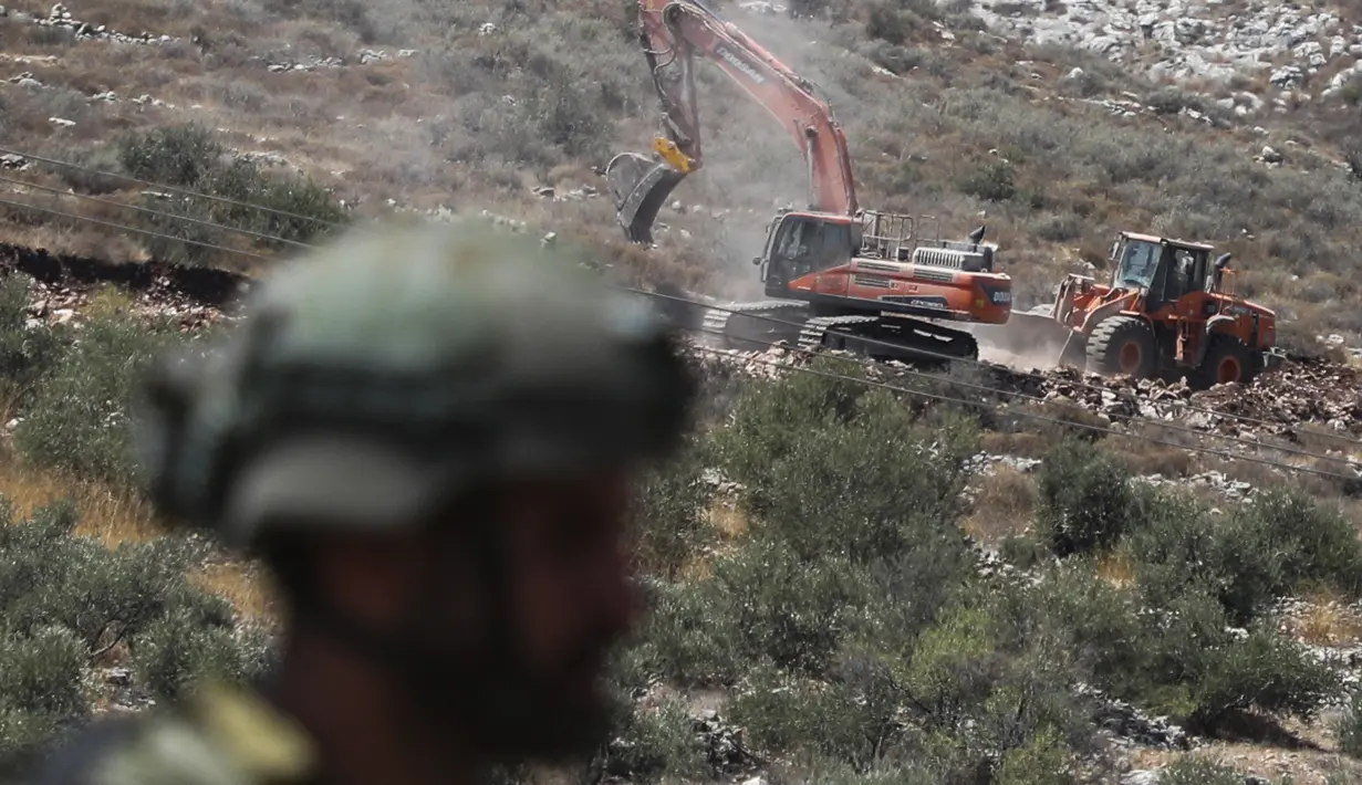 Tentara Israel berjaga sementara pembukaan lahan untuk permukiman Israel tengah berjalan di dekat Desa Shoufah, wilayah Tepi Barat (20/8/2020). (AFP/JAAFAR ASHTIYEH)