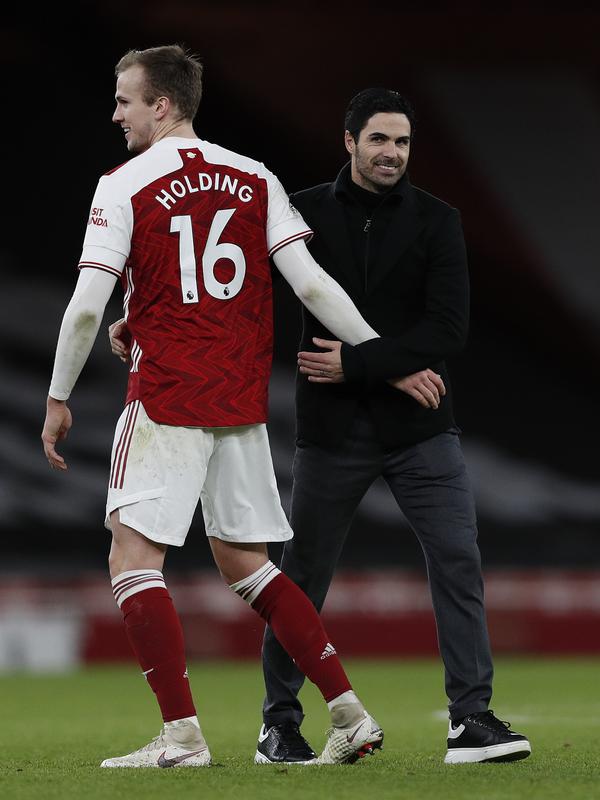 Pelatih Arsenal, Mikel Arteta (kanan) memberi selamat kepada bek Rob Holding usai pertandingan melawan Chelsea pada lanjutan Liga Inggris di Stadion Emirates di London, Minggu (27/12/2020). Mikel Arteta berharap, kemenangan ini menjadi titik kebangkitan timnya. (AFP/Pool/Adrian Dennis)
