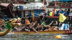 Peserta berlomba memacu perahu naga dalam peringatan tahunan Tuen Ng atau Festival Perahu Naga di Hong Kong, Kamis (9/6). Festival itu untuk mengenang penyair Tiongkok, Qu Yuan, yang 200 tahun lalu menenggelamkan diri di Sungai Mi Lo (Anthony WALLACE/AFP)