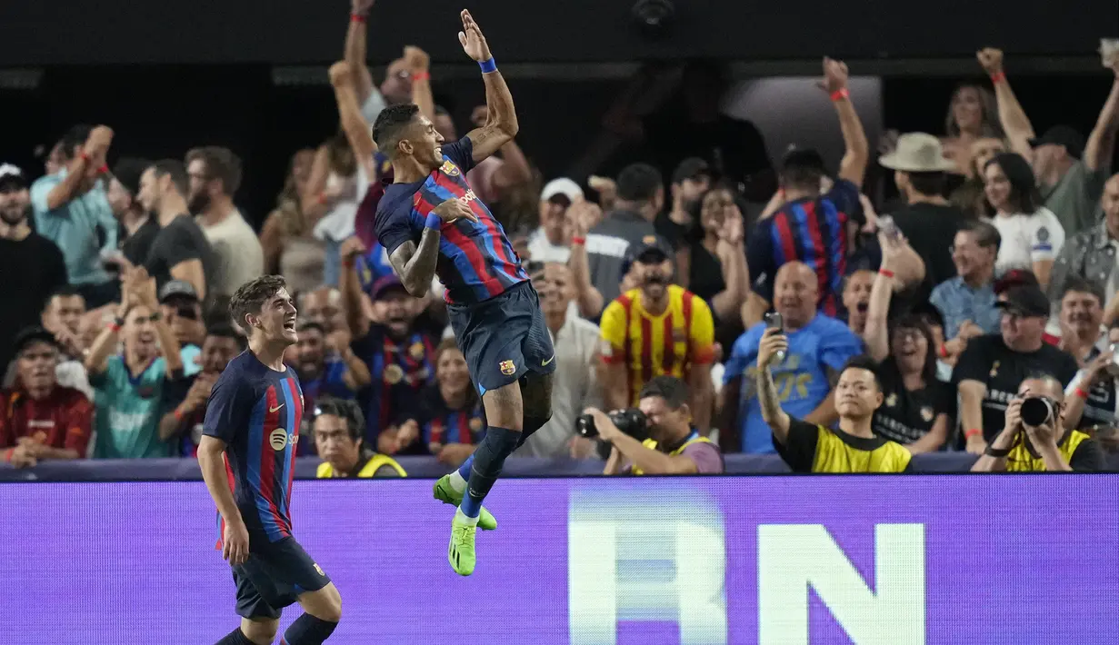 Pemain Barcelona, Raphinha (kanan) merayakan gol pertama timnya saat pertandingan persahabatan antara Real Madrid melawan Barcelona di Stadion Allegiant, Las Vegas, Amerika Serikat, Minggu (24/07/2022) pagi WIB. (AP/John Locher)