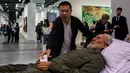 Seniman Tiongkok, Shen Shaomin meletakan ponsel di karyanya replika Fidel Castro dalam pameran Art Basel di Hong Kong (22/3). Karya replika yang mirip dengan aslinya tersebut terbuat dari acrylic dan silika gel. (AFP/Anthony Wallace)
