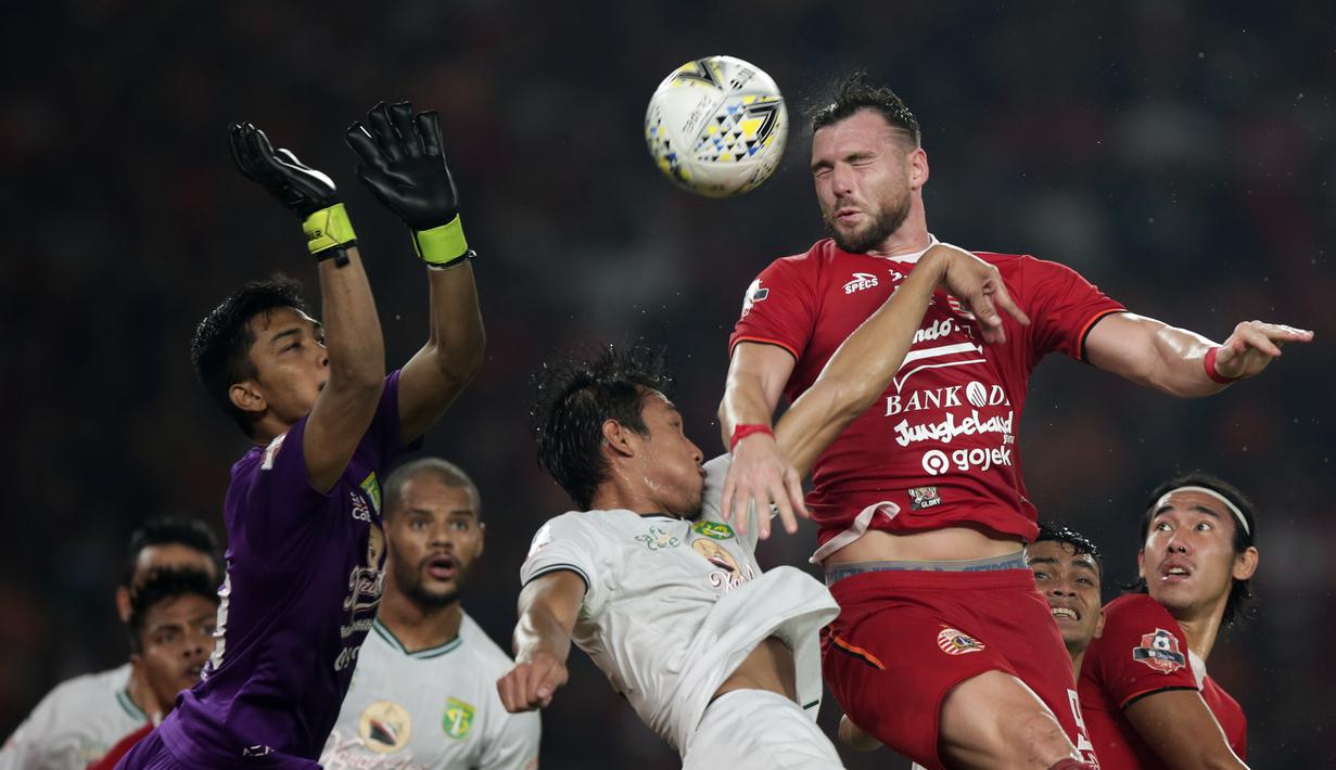 Striker Persija Jakarta, Marko Simic, berebut bola atas dengan pemain Persebaya pada laga Shopee Liga 1 di SUGBK, Jakarta, Selasa (17/12). Persebaya menang 2-1 atas Persija. (Bola.com/Yoppy Renato)