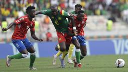 Penyerang Kamerun Aboubakar Vincent (tengah) bersaing dengan pemain Gambia James Gomez dan Sulayman Marreh pada pertandingan perempatfinal Piala Afrika 2021 di Japoma Stadium, Minggu (30/1/2022) dini hari WIB. Kamerun melangkah ke semifinal usai menang atas Gambia, 2-0. (AP Photo/Sunday Alamba)