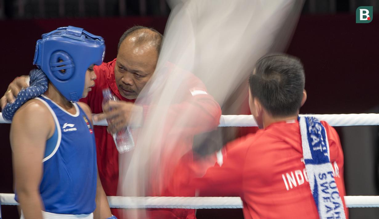 Petinju asal Indonesia Huswatun Hasanah mendengarkan instruksi pelatih saat melawan Sudaporn Seesondee asal Thailand di babak semifinal kelas ringan (57-60 kg) Asian Games 2018 di JIExpo Kemayoran Jakarta, Jumat (31/8/2018). (Bola.com/Peksi Cahyo)