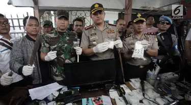 Kapolres Jakarta Barat Kombes Pol Hengki Haryadi didampingi Dandim 0503 Jakbar Letkol Kav Andre Henry Masengi menunjukkan barang bukti narkoba usai melakukan penggerebekan di Kampung Ambon, Cengkareng, Jakarta, Rabu (24/1). (Liputan6.com/Arya Manggala)