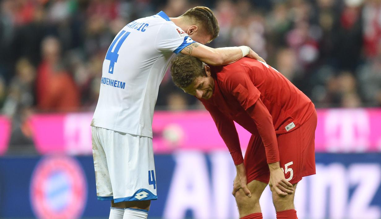 Pemain Hoffenheim, Ermin Bicakcic (kiri) memegang pundak pemain Bayern Munich, Thomas Mueller (kanan) usai laga Bundesliga di Stadion Alianz Arena, Munich, (5/11/2016). (AFP/ Christof Stache)