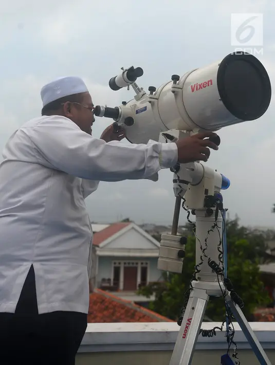 Aksi petugas saat meneropong posisi hilal (bulan) dari Pondok Pesanteren Al-Hidayah Jakarta, Selasa (15/5). (Merdeka.com/Imam Buhori)