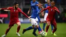 Gelandang Italia, Marco Verratti membawa bola dari kawalan dua pemain Portugal, Bernardo Silva dan Joao Mario selama pertandingan UEFA Nations League di Stadion San Siro, Milan (17/11). Portugal berhasil lolos ke semifinal. (AFP Photo/Marco Bertorello)