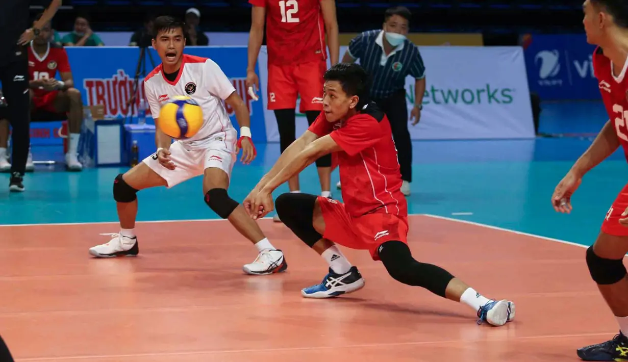 Pemain Timnas Voli Putra Indonesia, Farhan Halim (tengah) berusaha menerima bola pada laga final SEA Games 2021 melawan tuan rumah Vietnam yang berlangsung di Dai Yan Sports Arena, Quang Ninh Vietnam, Minggu, 22 Mei 2022. Skuat asuhan Jiang Jie berhasil menang telak dengan skor 3-0 (25-22, 25-18, dan 25-15). (Foto: NOC Indonesia/MP Media/Gilang Riandi)