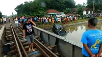 Terobos jalur kereta tanpa palang pintu, mobil Daihatsu Xenia tercebur ke sungai Sidoarjo, Jawa Timur, sehingga menewaskan 3 penumpangnya. (Liputan6.com/Dhimas Prasaja)