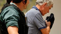 Mantan Presiden RFEF, Angel Maria Villar dibawa oleh polisi Garda Sipil Spanyol menuju markas besar Federasi di Las Rozas, Spanyol (18/7). Selain Villar, Putranya dan Wakil Presiden RFEF juga terlibat kasus yang sama. (AP Photo / Francisco Seco)