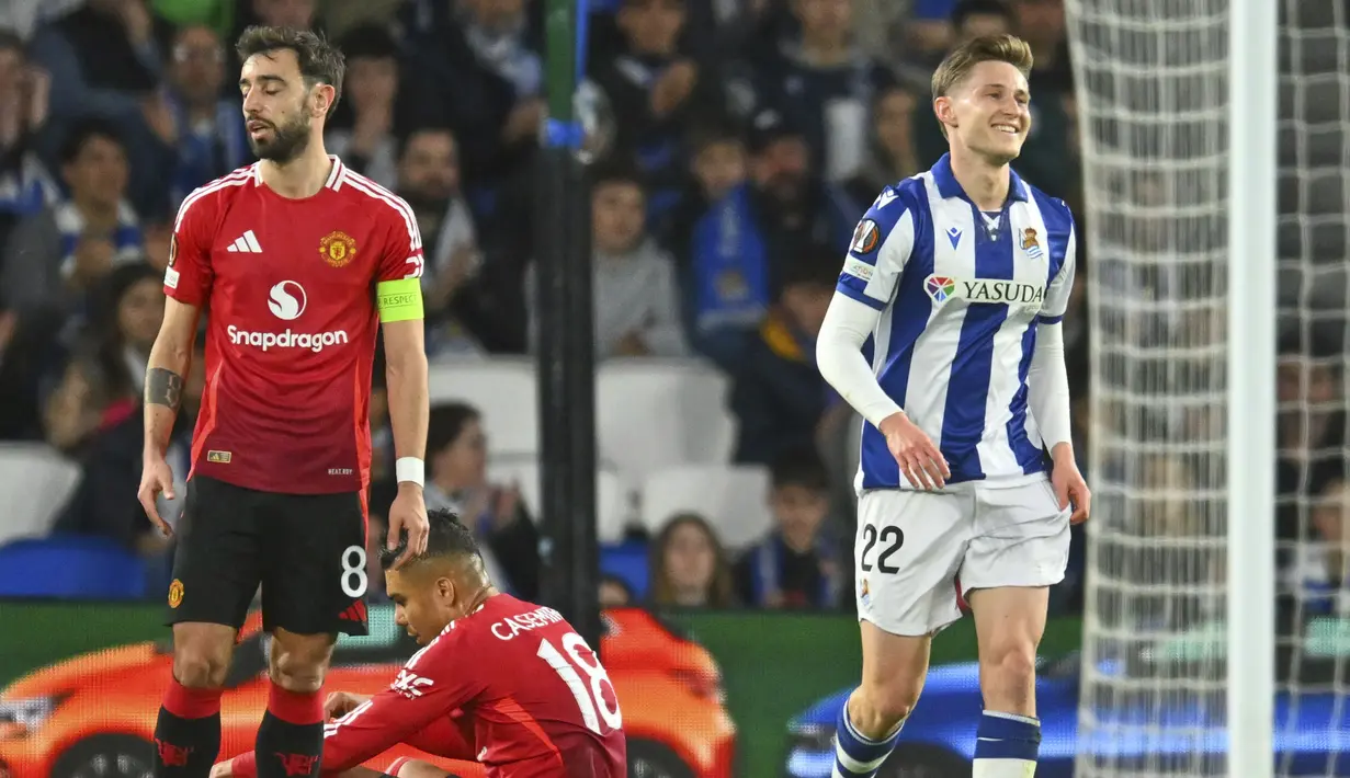 Ekspresi kecewa pemain Manchester United, Bruno Fernandes (kiri) setelah pemain Real Sociedad, Mikel Oyarzabal mencetak gol penyeimbang 1-1 melalui tendangan penalti dalam laga leg 1 babak 16 besar Liga Europa 2024/2025 di Anoeta Stadium, San Sebastian, Spanyol, Jumat (07/03/2025) dini hari WIB. (AP Photo/Miguel Oses)