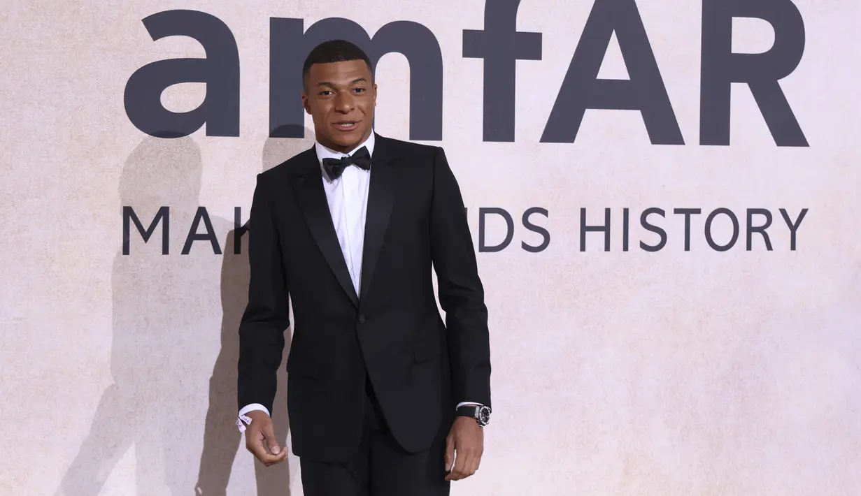 <p>Penyerang PSG, Kylian Mbappe berpose untuk fotografer setibanya menghadiri AmfAR Cinema Against AIDS Benefit selama festival film internasional Cannes ke-75 di Hotel du Cap-Eden-Roc, Cap d'Antibes, Prancis selatan, Kamis (26/5/2022). Mbappe tampil mengenakan jas hitam berdasi kupu-kupu. (AP Photo/Vianney Le Caer)</p>