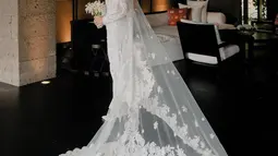 Veil panjang yang menjuntai indah semakin melengkapi penampilannya di hari bahagia tersebut. Hiasan kepala berupa kembang goyang silver menambah nuansa mewah dan anggun. Shenina Cinnamon juga menambahkan perhiasan berupa kalung dan anting berwarna silver yang serasi dengan gaunnya. (Liputan6.com/IG/@sheninacinnamon)