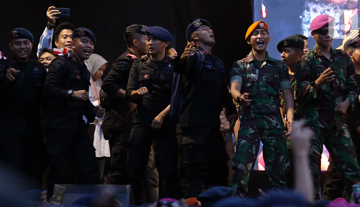 Anggota TNI - Polri berjoget saat panggung hiburan bertajuk dangdut di Lapangan DPR Senayan, Jakarta, Senin (21/10/2019). Di halaman DPR, digelar agenda dangdutan untuk menghibur aparat keamanan yang berjaga pada saat Pelantikan Presiden dan Wakil Presiden. (Liputan6.com/Johan Tallo)